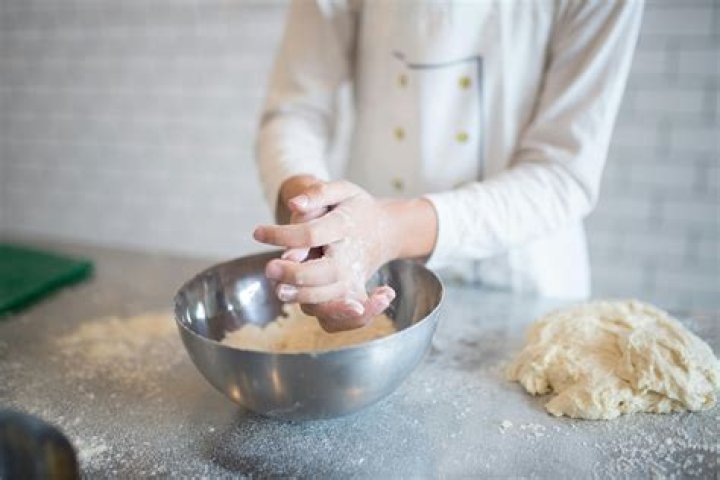 A person mixing dough. A person mixing dough.