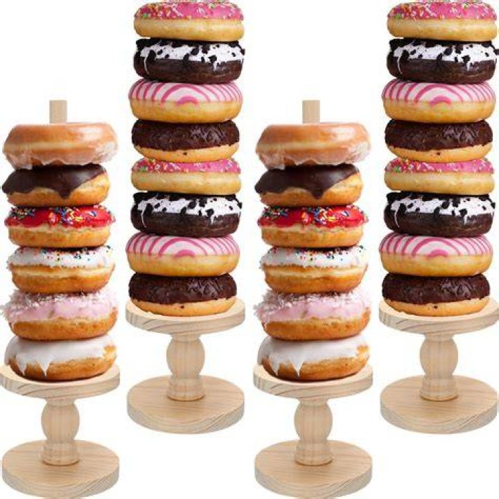 Doughnuts and bagel display and a person backing. Doughnuts and bagel display and a person backing.