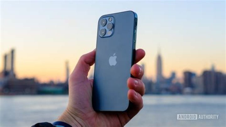 iPhone 12 Pro holding bakc of phone against sunset iPhone 12 Pro holding bakc of phone against sunset