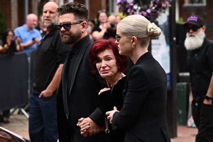 Jack Osbourne and Sharon Osbourne talking on a balcony.